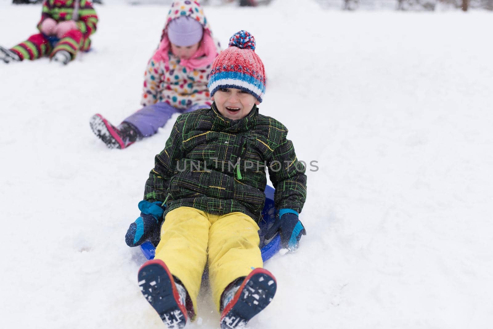 group of kids having fun and play together in fresh snow by dotshock