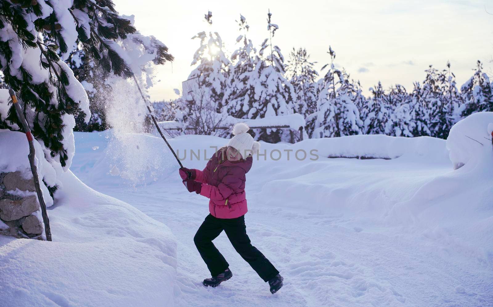 little girl having fun  throwing fresh snow at beautiful sunny winter day