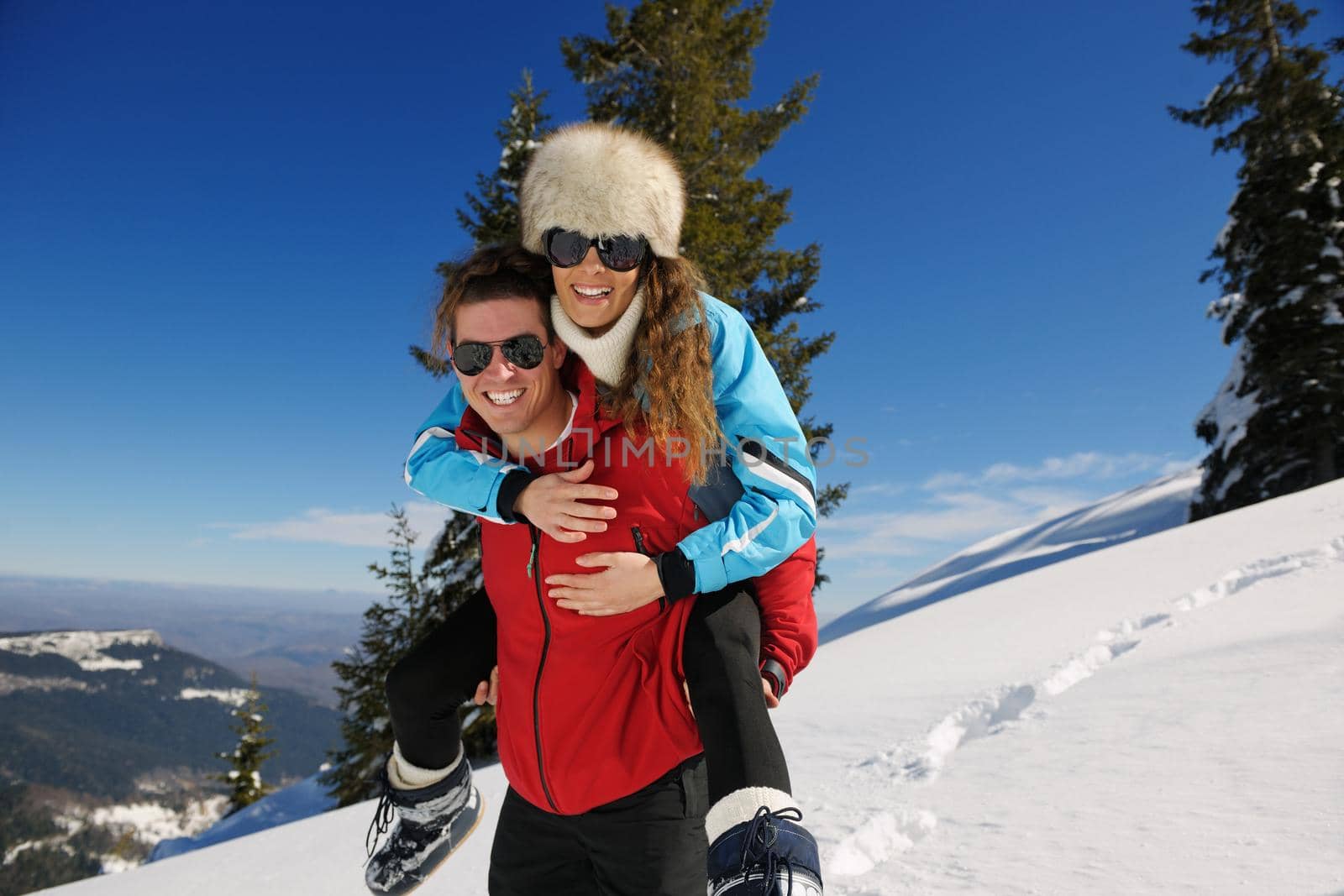 Young Couple In winter Snow Scene at  beautiful sunny day