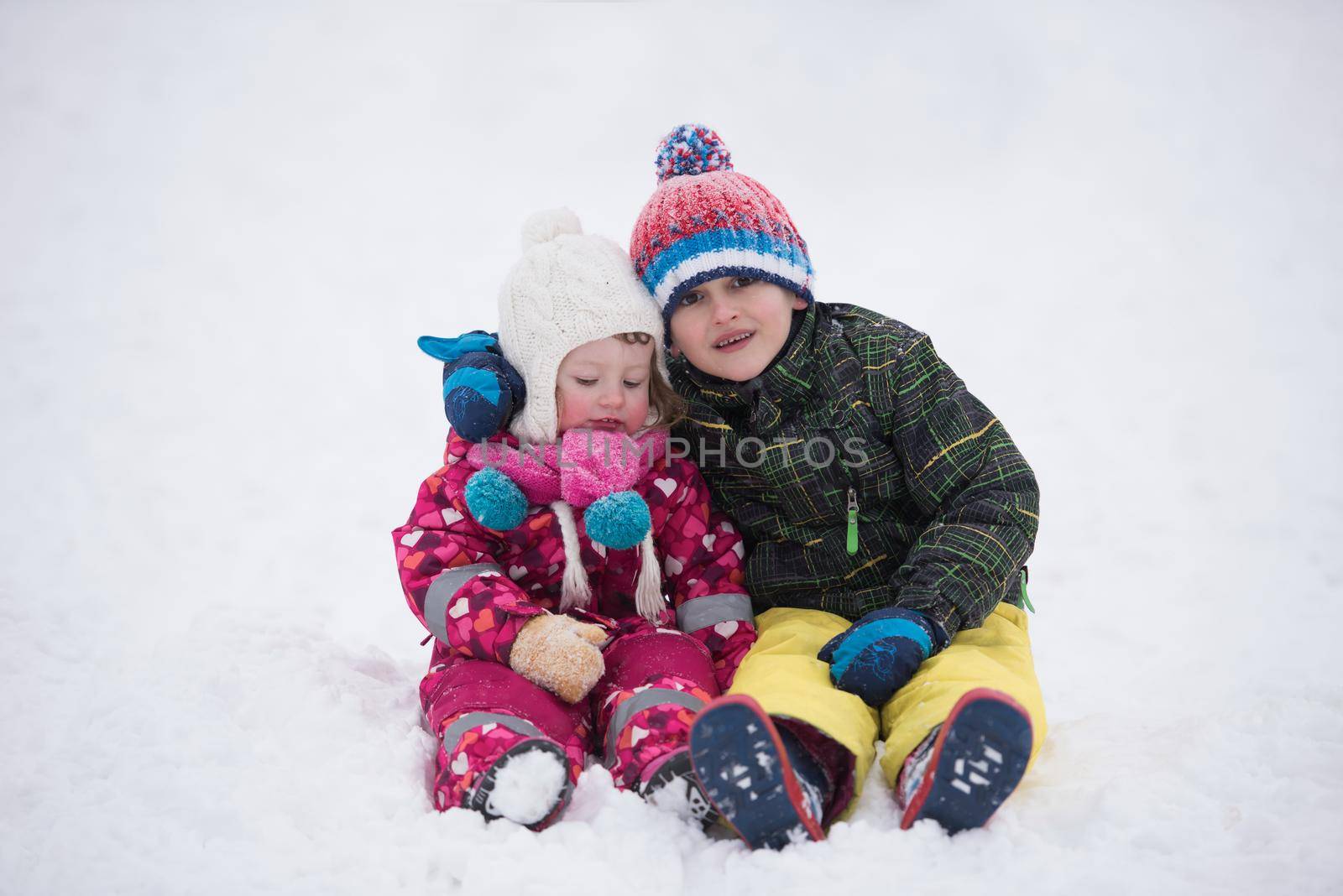 children group  having fun and play together in fresh snow by dotshock