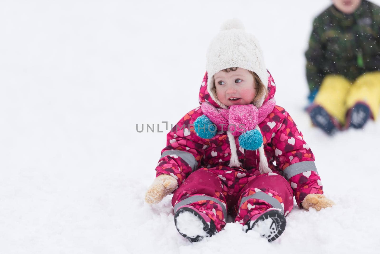 portrait of happy smiling little girl child outdoors having fun and playing on snowy winter day