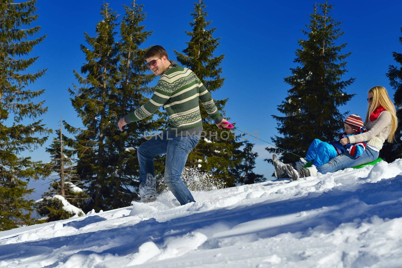 Winter season. Happy family having fun on fresh snow on vacation.