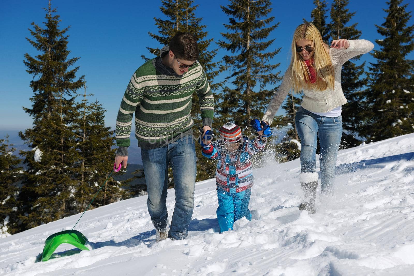 Winter season. Happy family having fun on fresh snow on vacation.