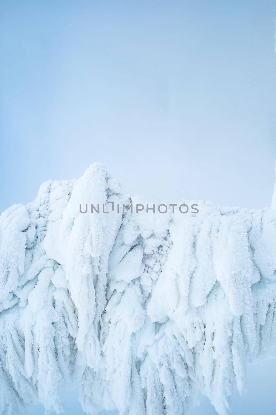 Ice figures under large amount of ice and snow on light blue background