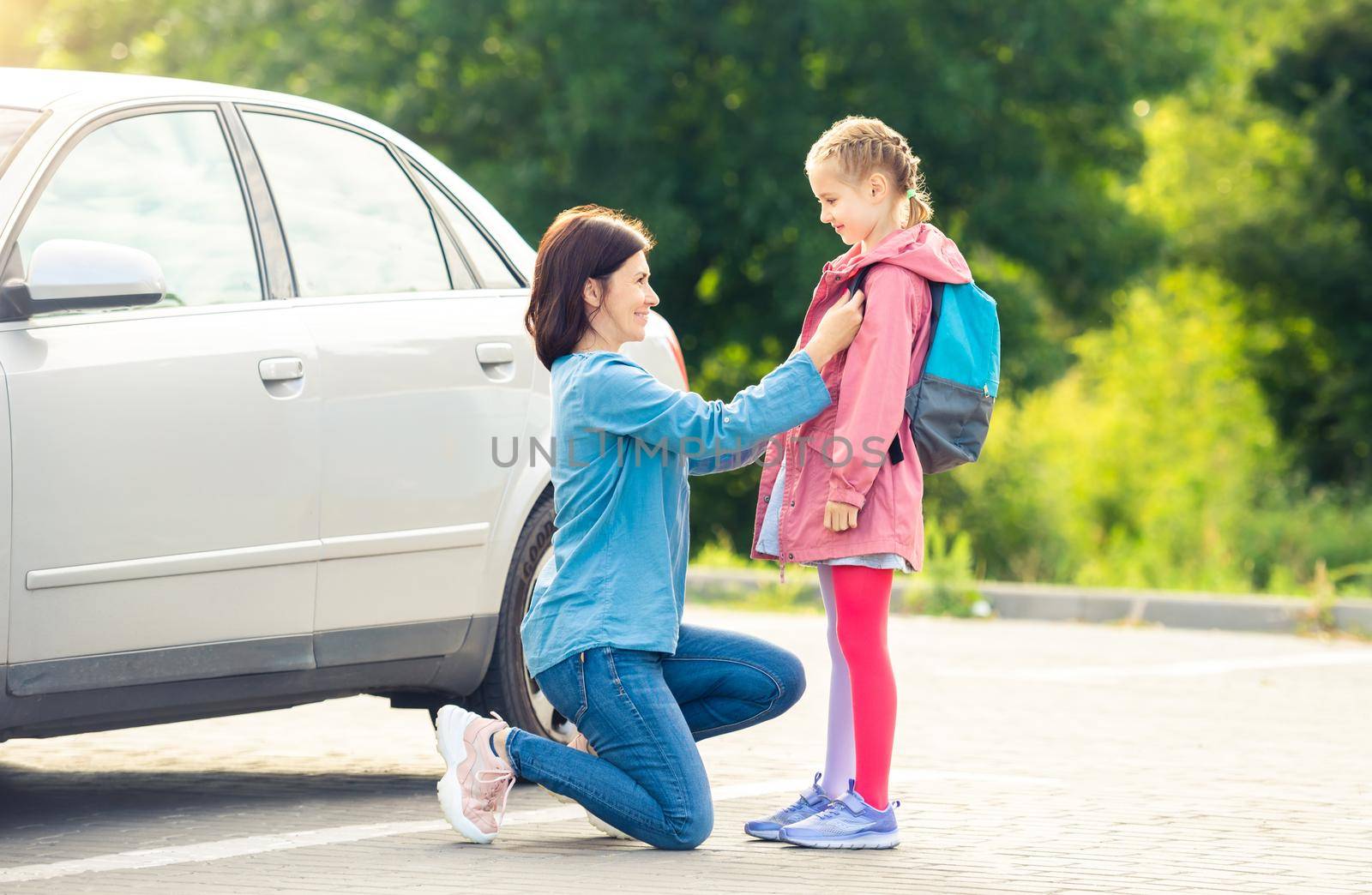 Smiling mother bringing daughter to school by GekaSkr