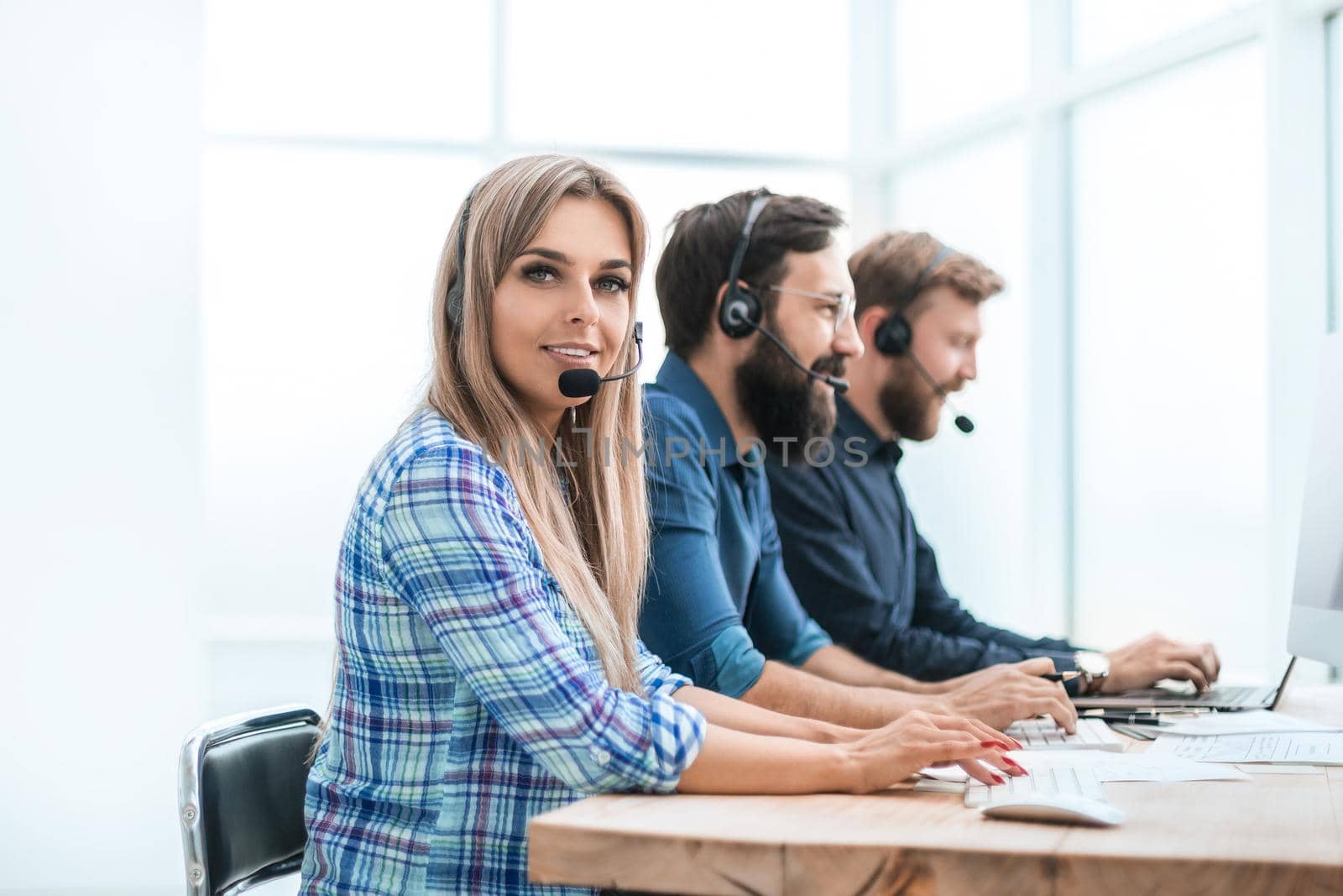 young woman with colleagues working in the office of the call center. photo with copy space