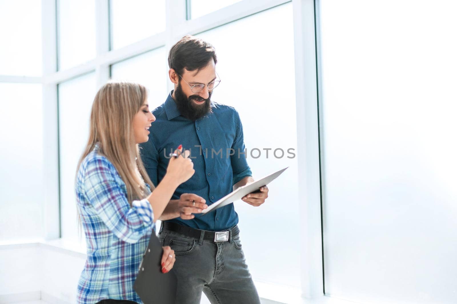 boss and assistant discussing work schedule is standing in the office corridor. office weekdays