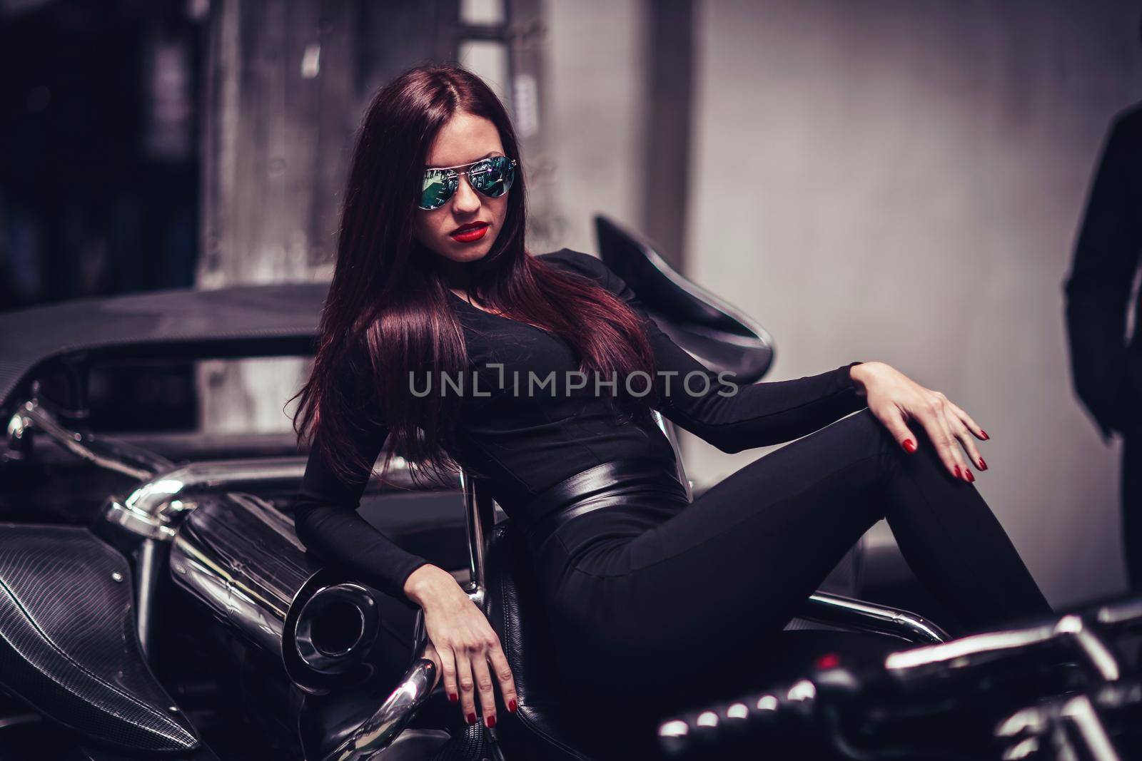stylish woman model posing on a custom motorcycle . photo with copy space