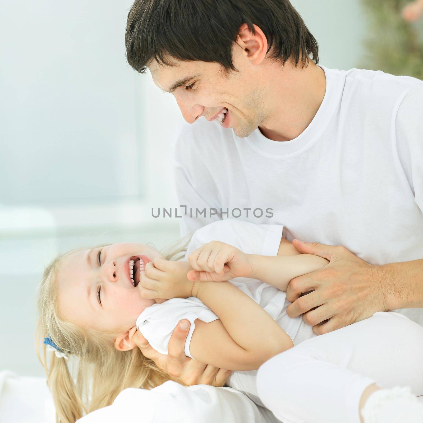 Dad and his daughter child girl are playing, smiling and hugging. Family holiday and togetherness.