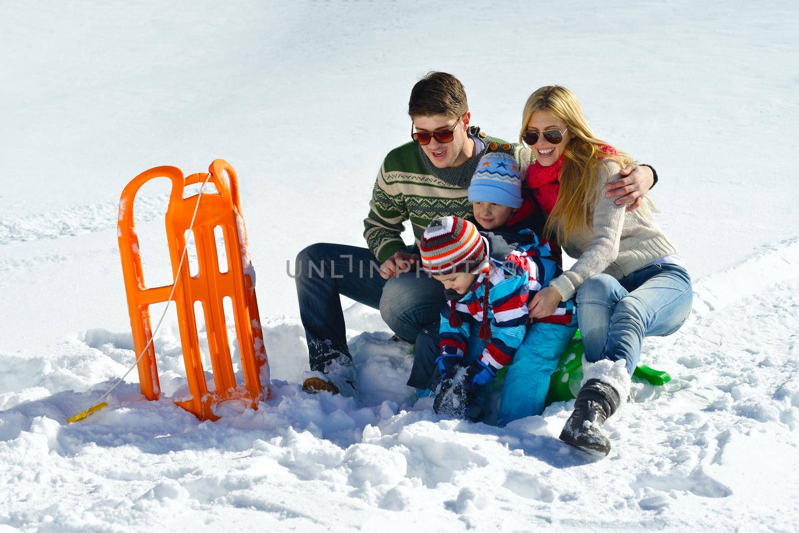 Winter season. Happy family having fun on fresh snow on vacation.