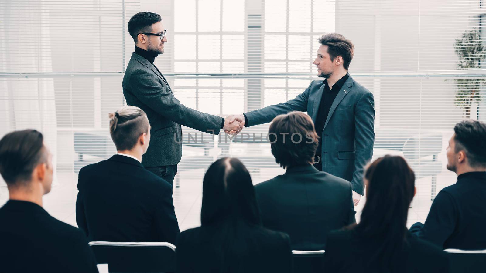 happy colleagues shaking hands with each other. meetings and partnerships