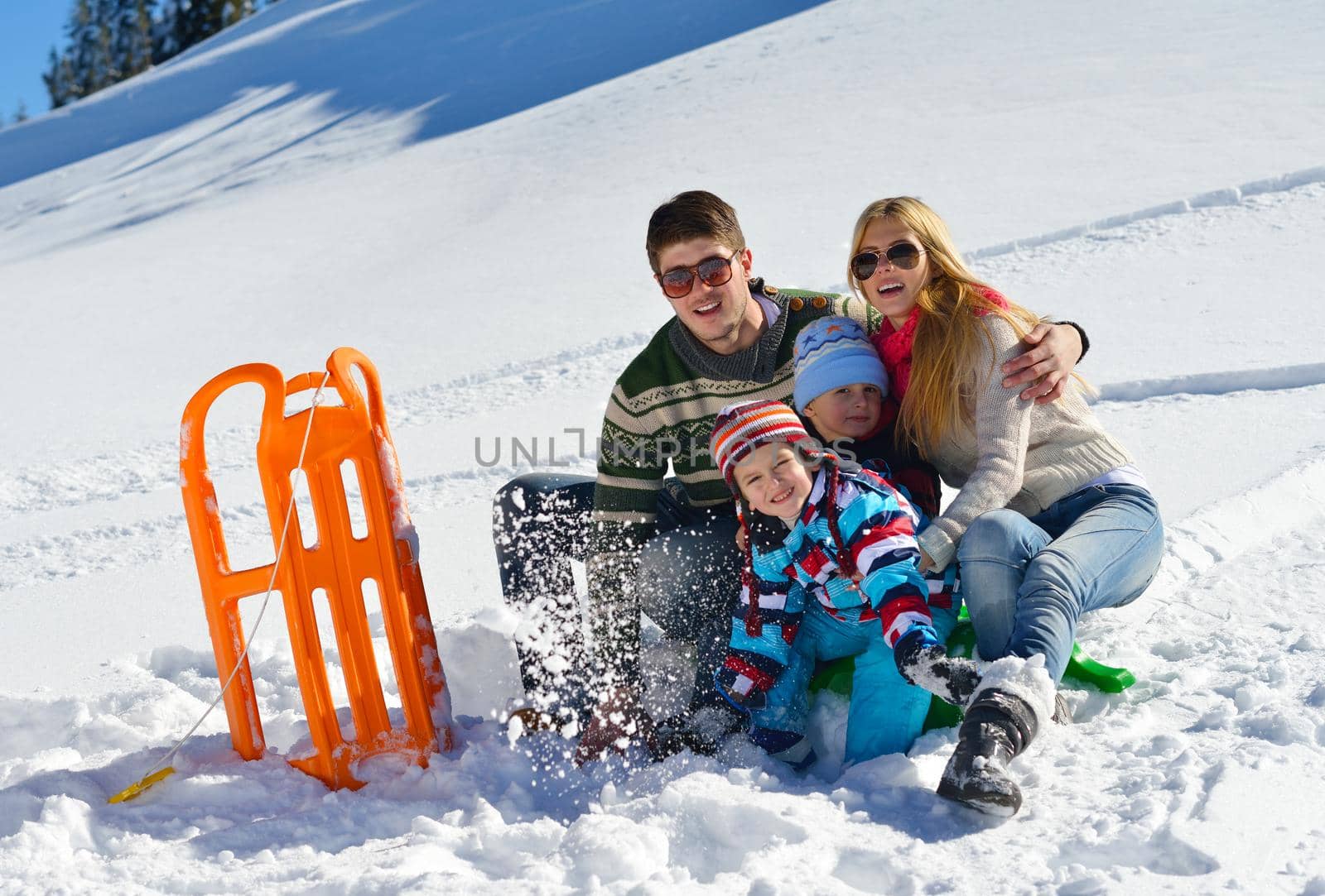 Winter season. Happy family having fun on fresh snow on vacation.