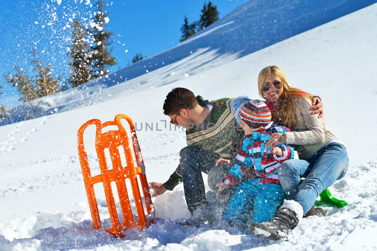 Winter season. Happy family having fun on fresh snow on vacation.