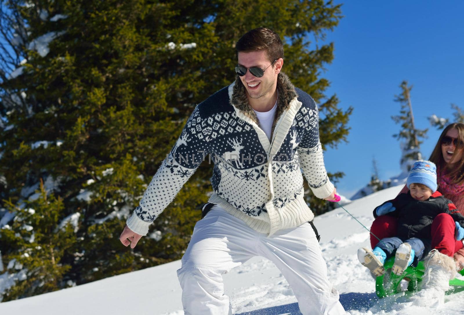 Winter season. Happy family having fun on fresh snow on vacation.