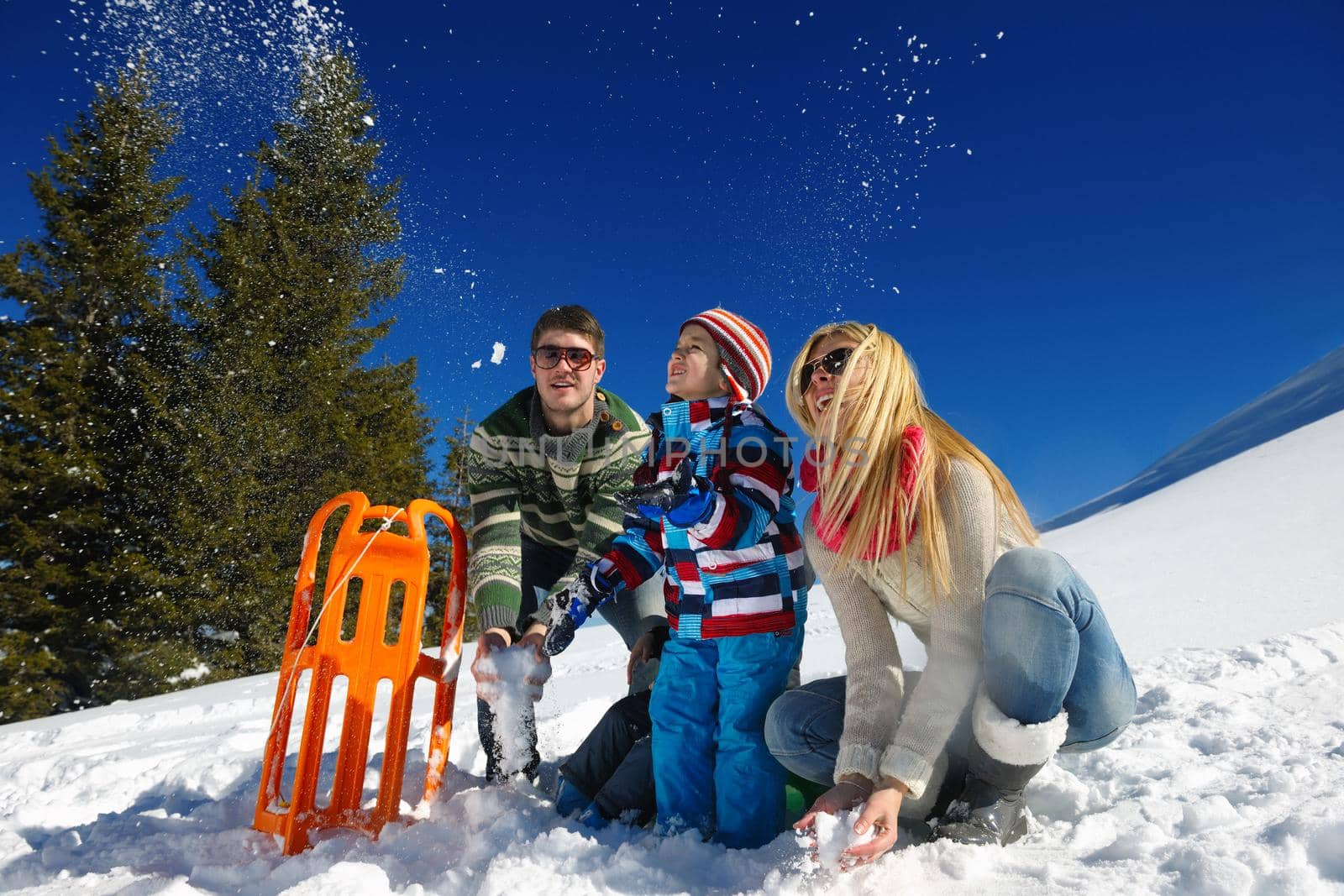 Winter season. Happy family having fun on fresh snow on vacation.