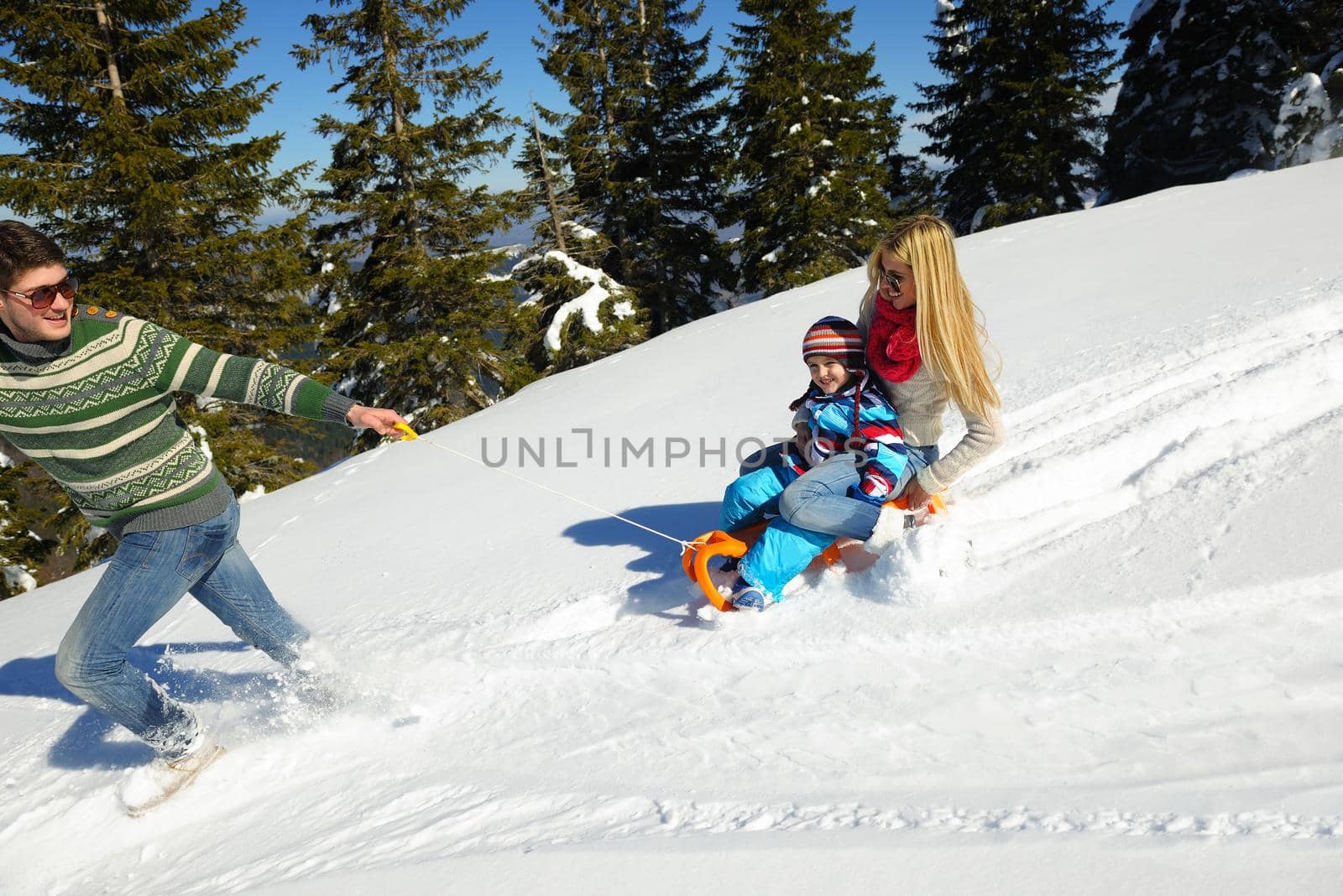 Winter season. Happy family having fun on fresh snow on vacation.