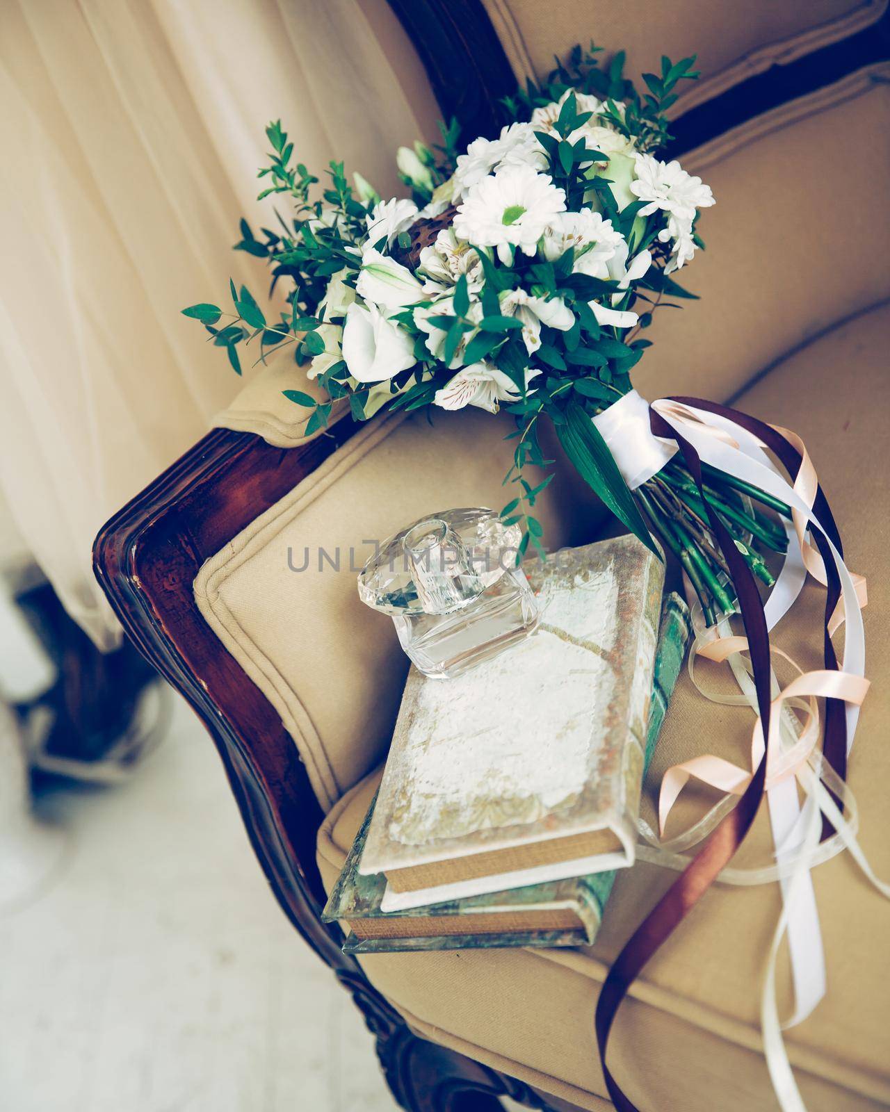 close up. bouquet and perfume bottle on vintage sofa.