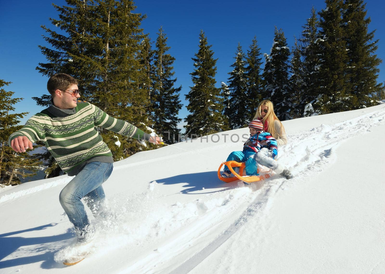 Winter season. Happy family having fun on fresh snow on vacation.