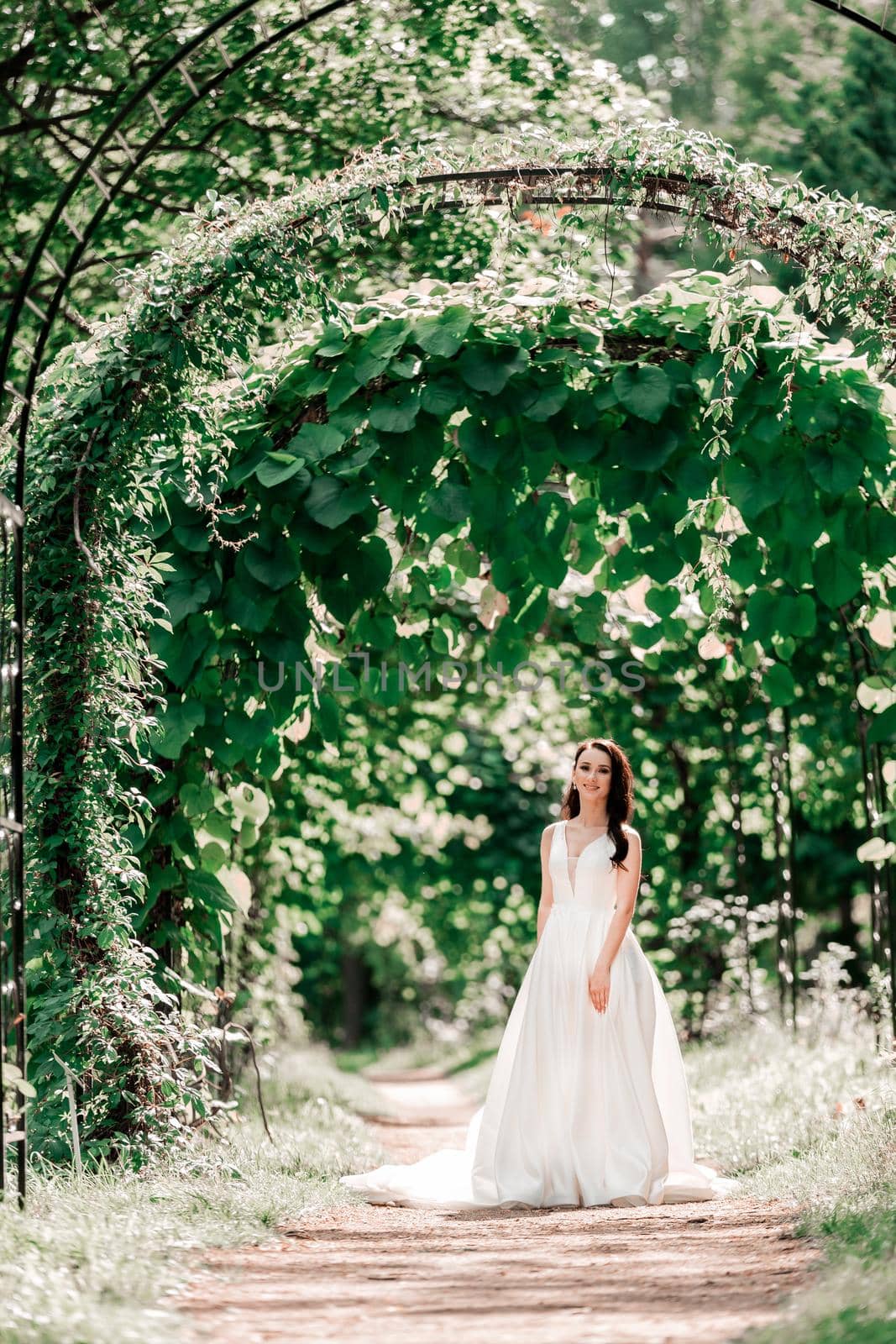 portrait of a happy bride standing under an arch in the Park. events and traditions