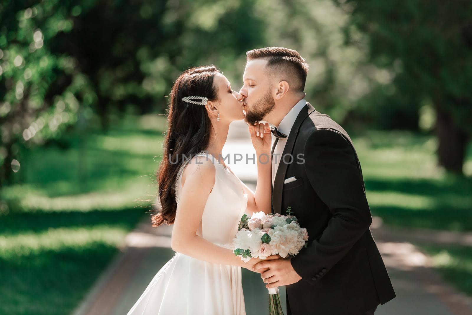 loving couple of newlyweds standing on a Park alley. events and traditions