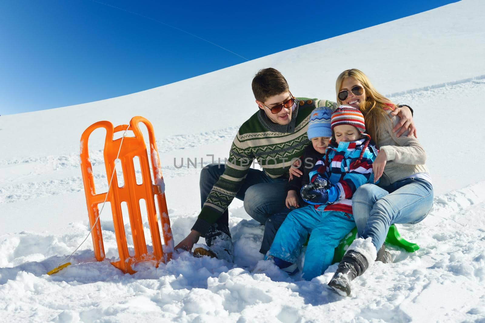 family having fun on fresh snow at winter vacation by dotshock