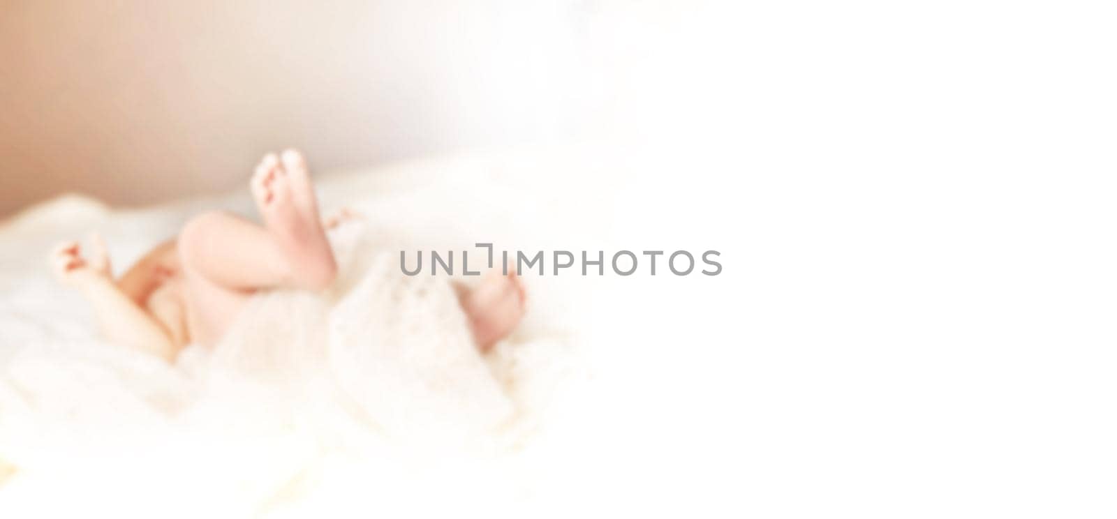 blurred image for the advertising text. image of a newborn baby lying on the couch in the nursery. photo with copy space