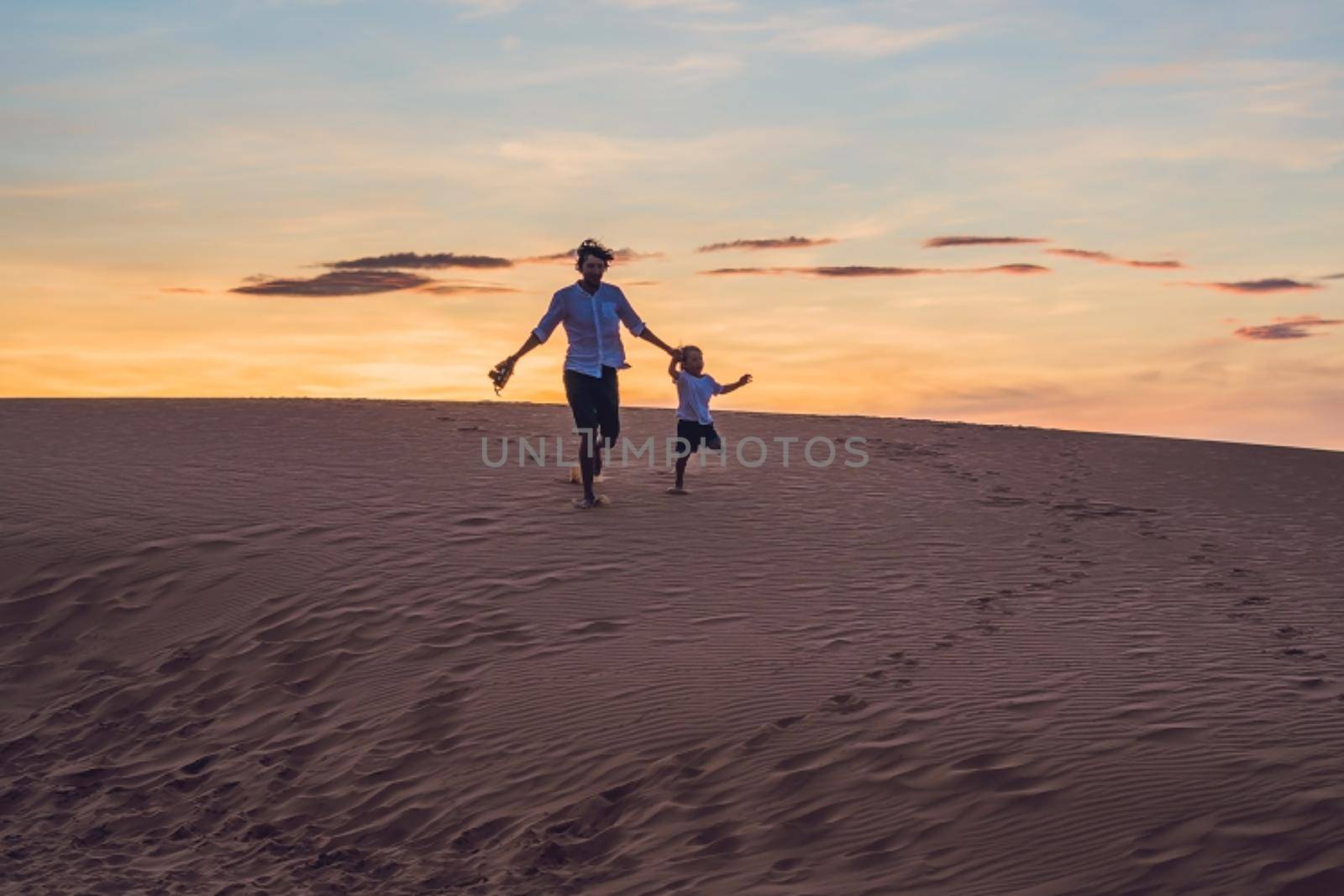 Father and son at the red desert at dawn. Traveling with children concept by galitskaya