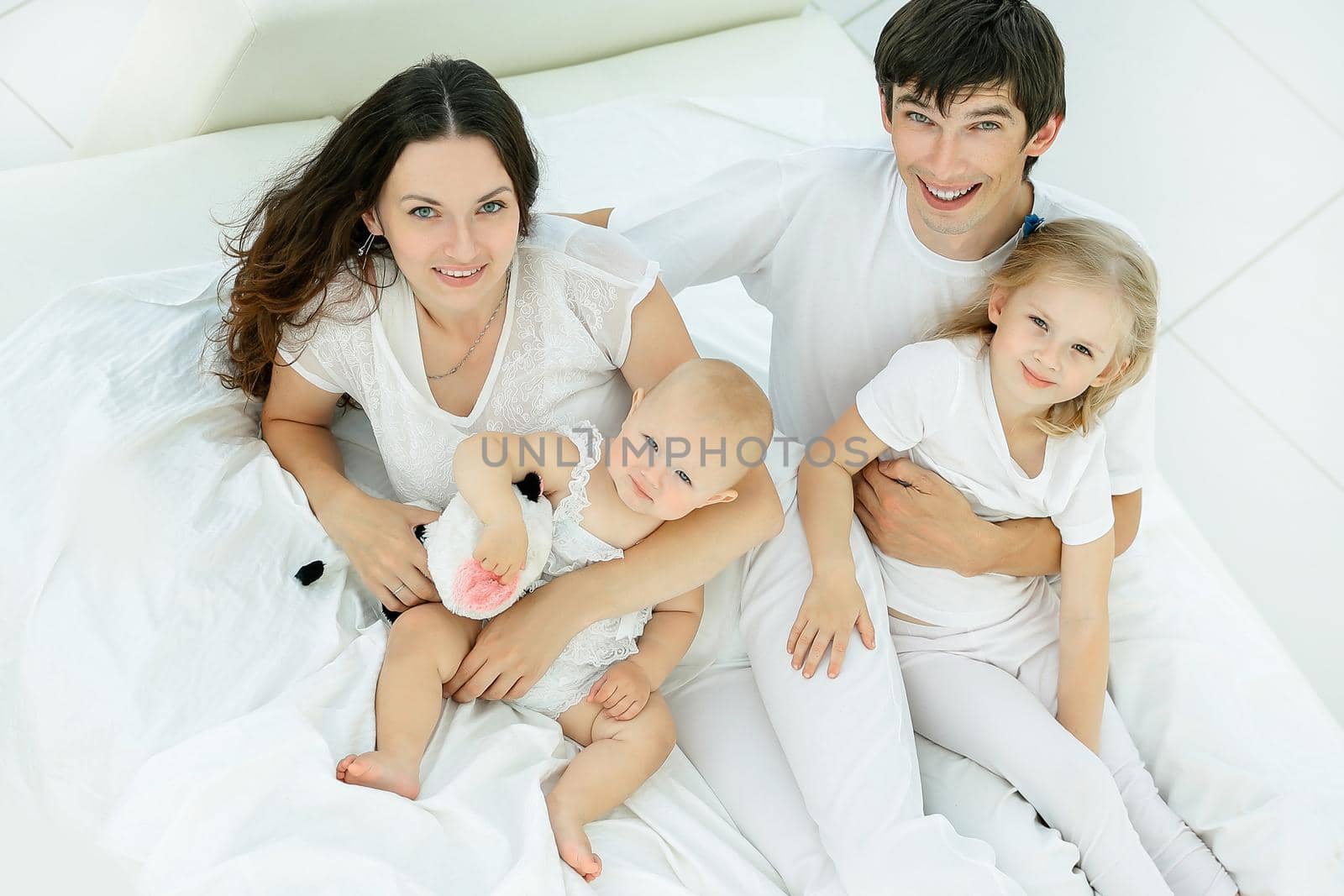 happy family on the bed in the bedroom in the morning by SmartPhotoLab