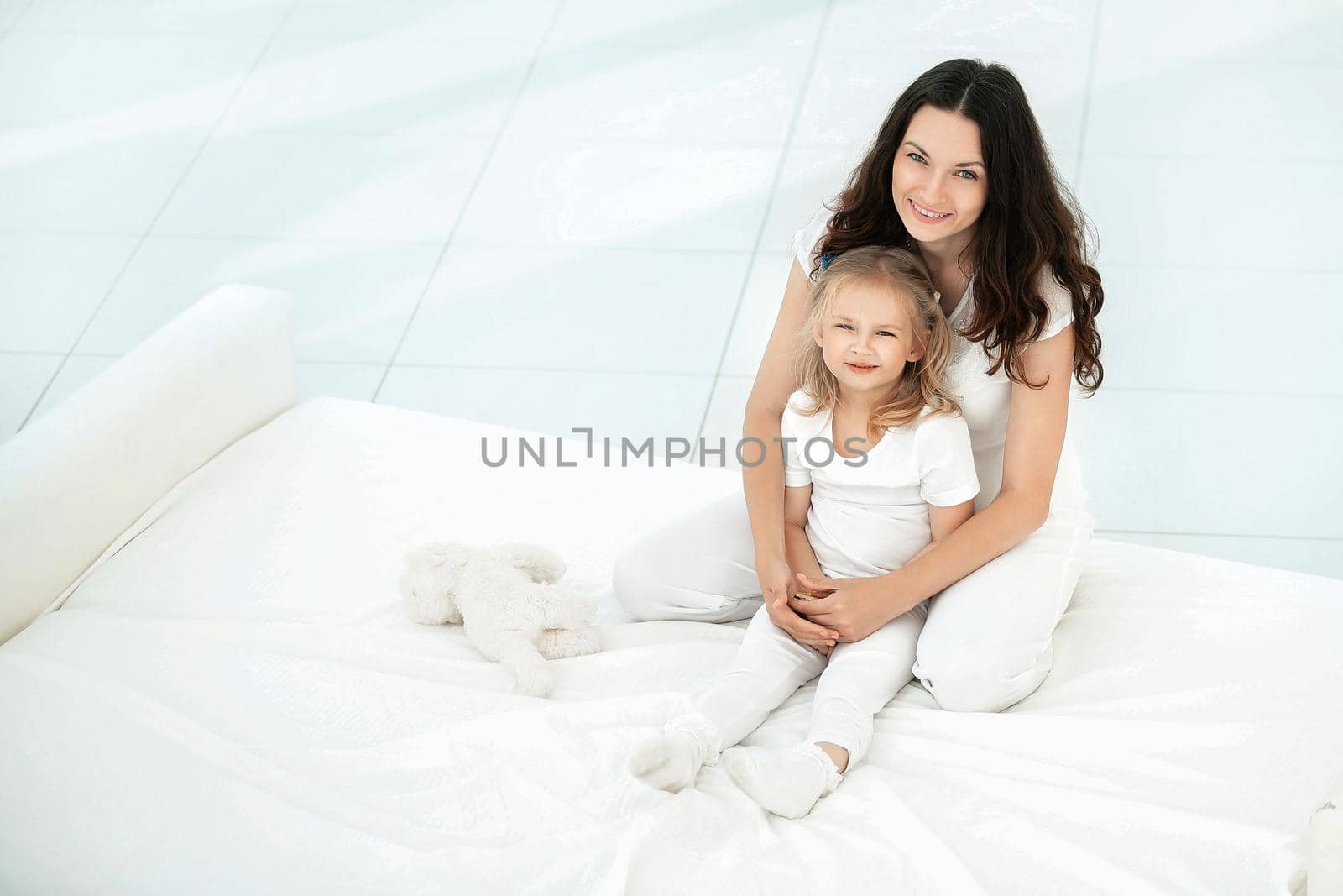 mother and daughter playing on the sofa in the living room.the concept of parenthood