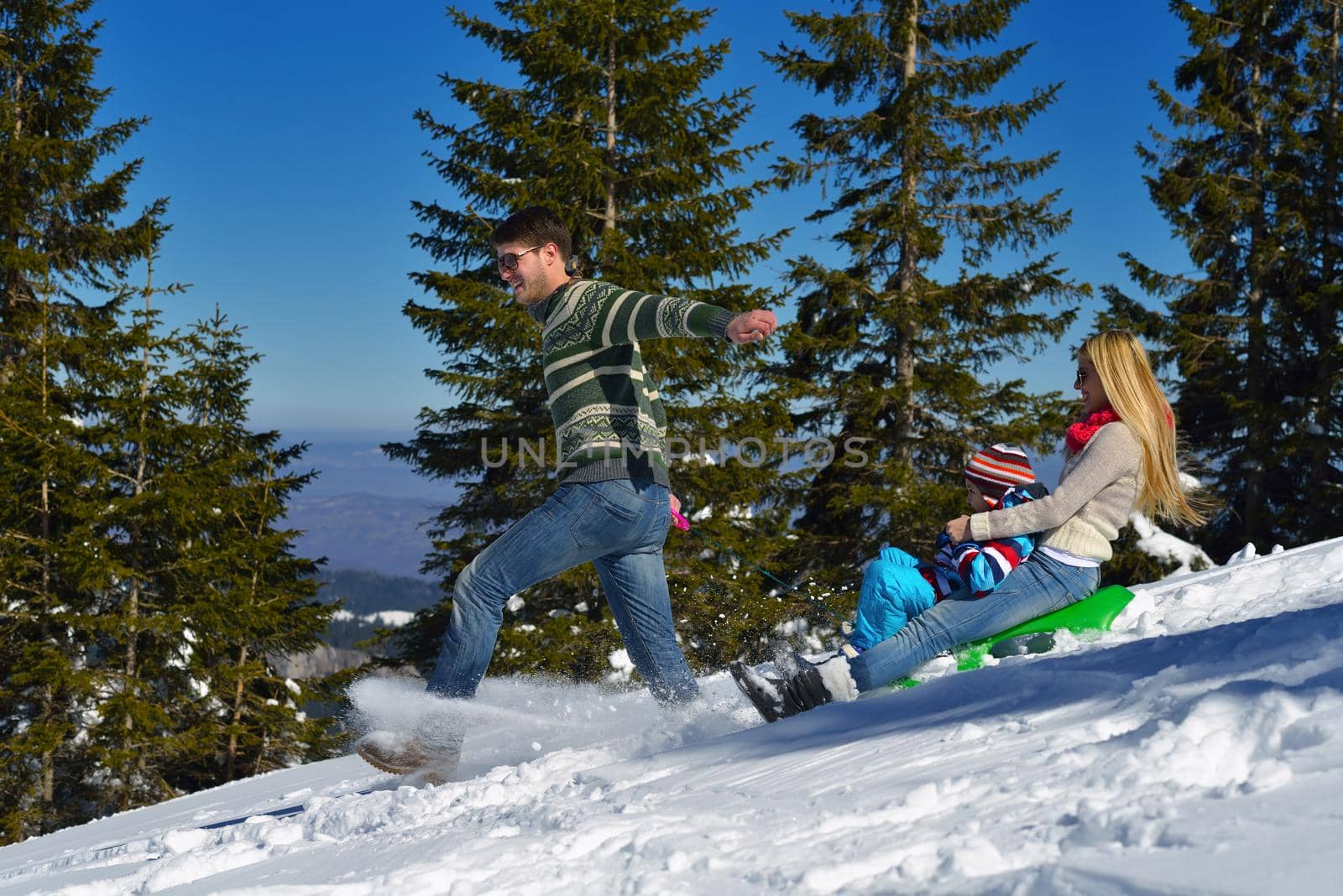 Winter season. Happy family having fun on fresh snow on vacation.