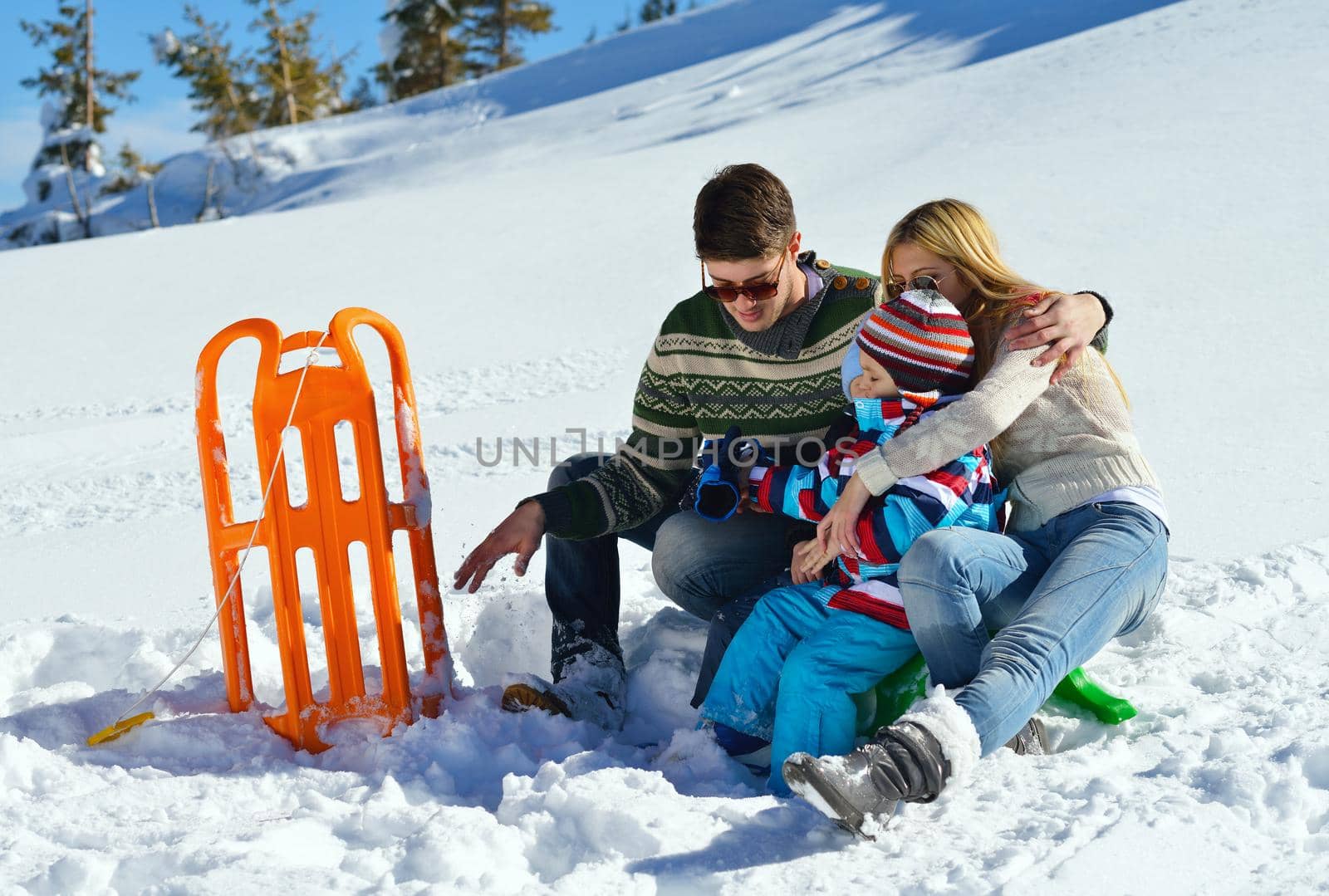 Winter season. Happy family having fun on fresh snow on vacation.