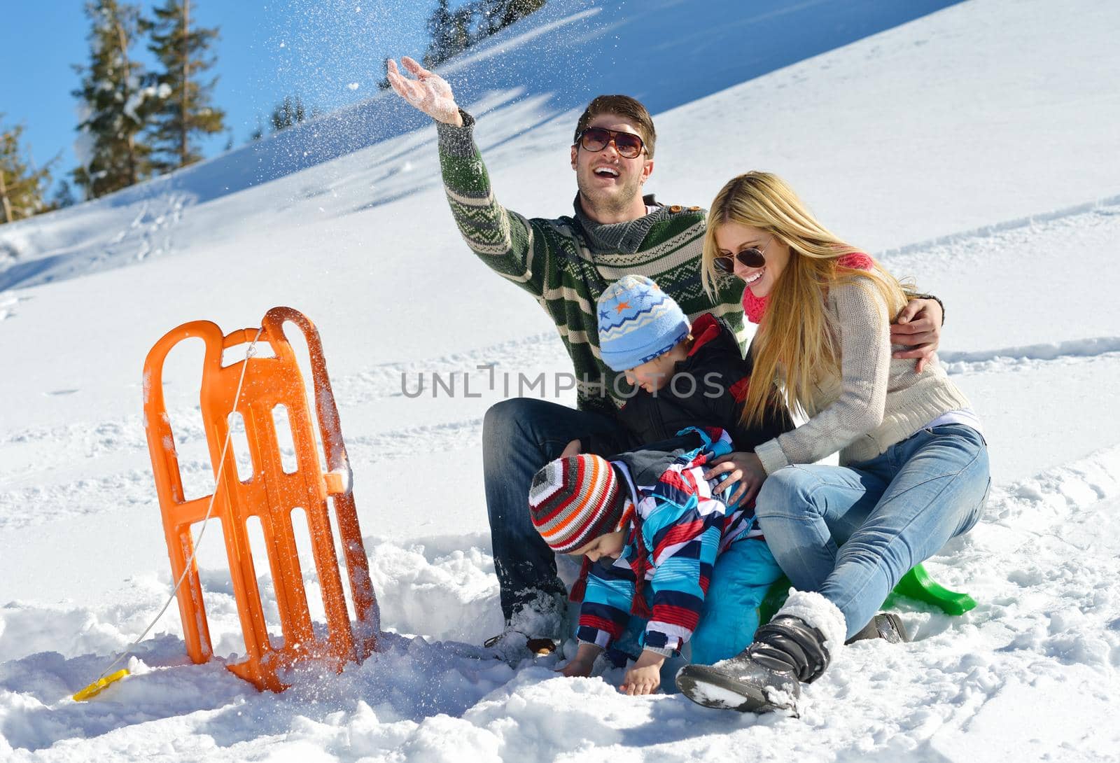 Winter season. Happy family having fun on fresh snow on vacation.