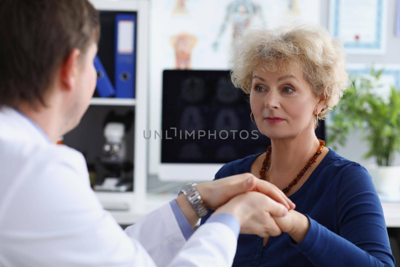 Portrait of professional doctor hold patients hand and calm down after appointment. Senior woman in doctors cabinet, checkup health. Medicine, help concept