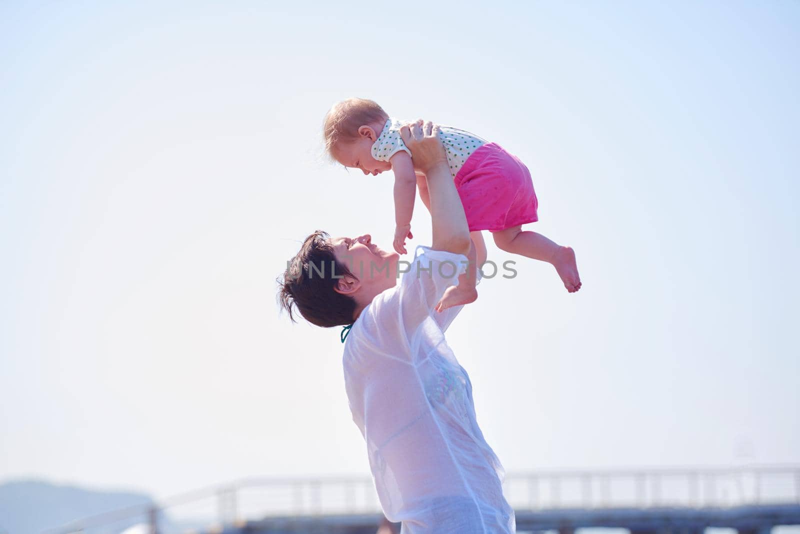 mom and baby on beach  have fun by dotshock