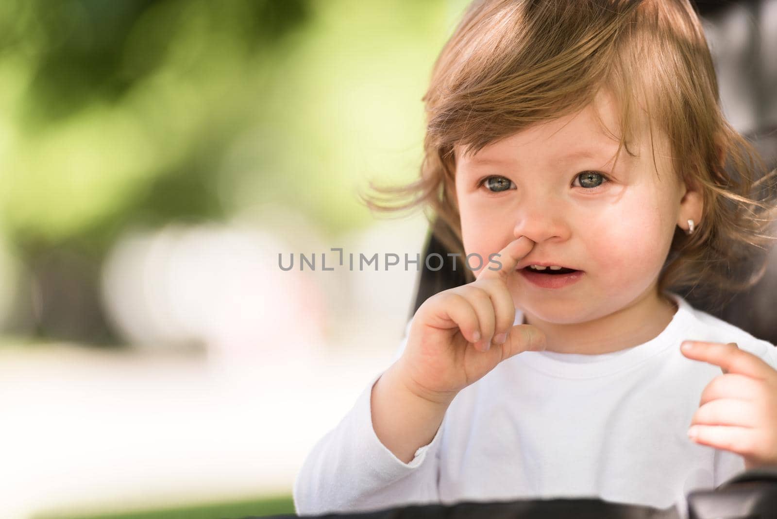 little and very beautiful baby girl sitting in the pram and waiting for mom