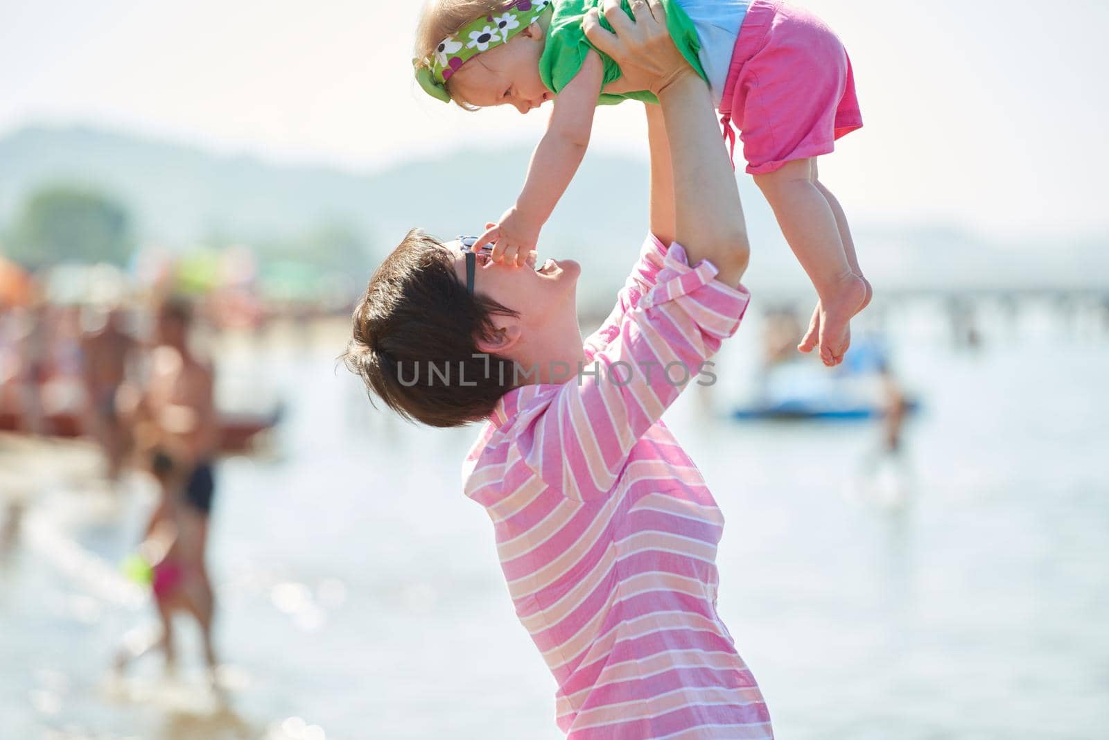 mom and baby on beach  have fun by dotshock