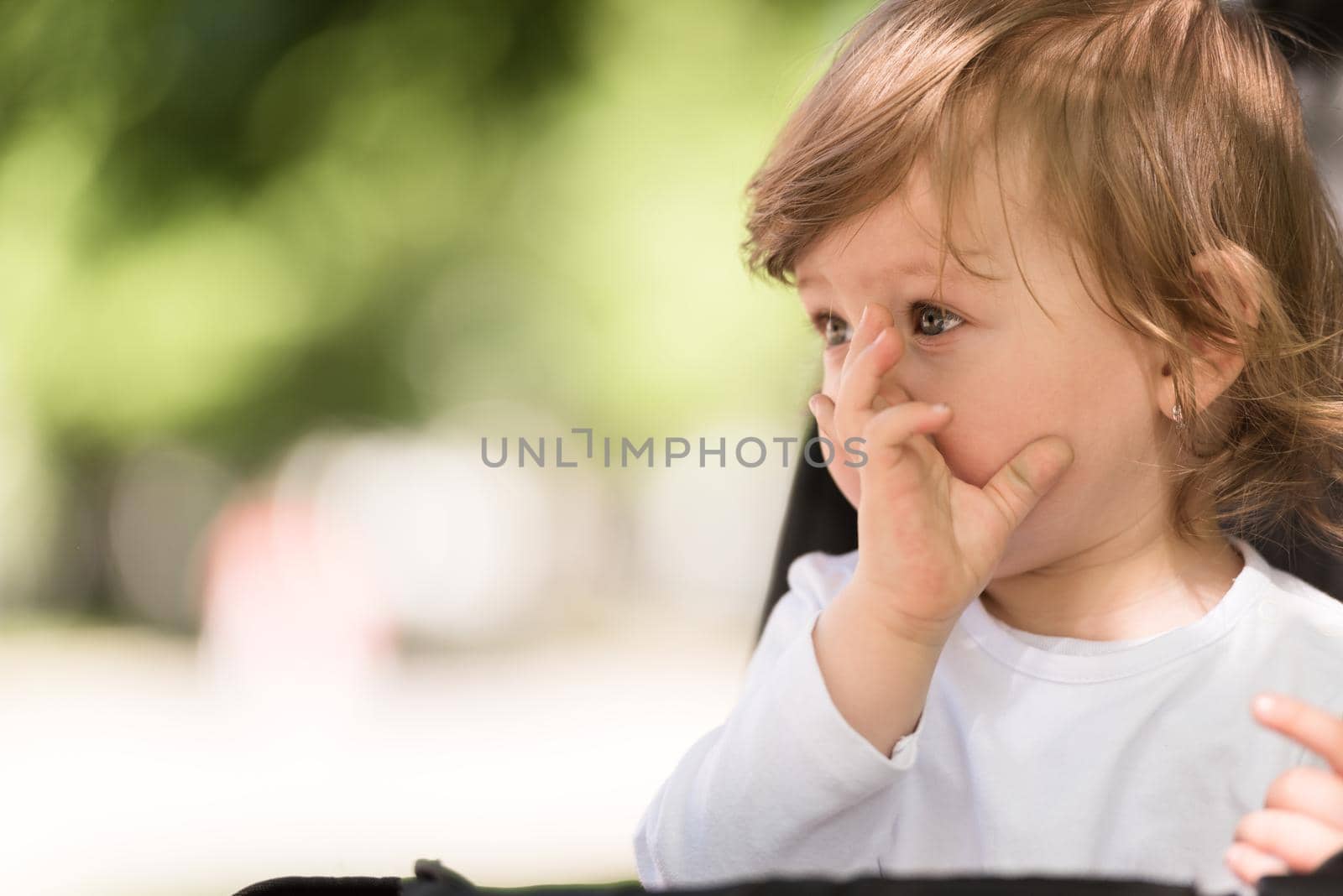 little and very beautiful baby girl sitting in the pram and waiting for mom