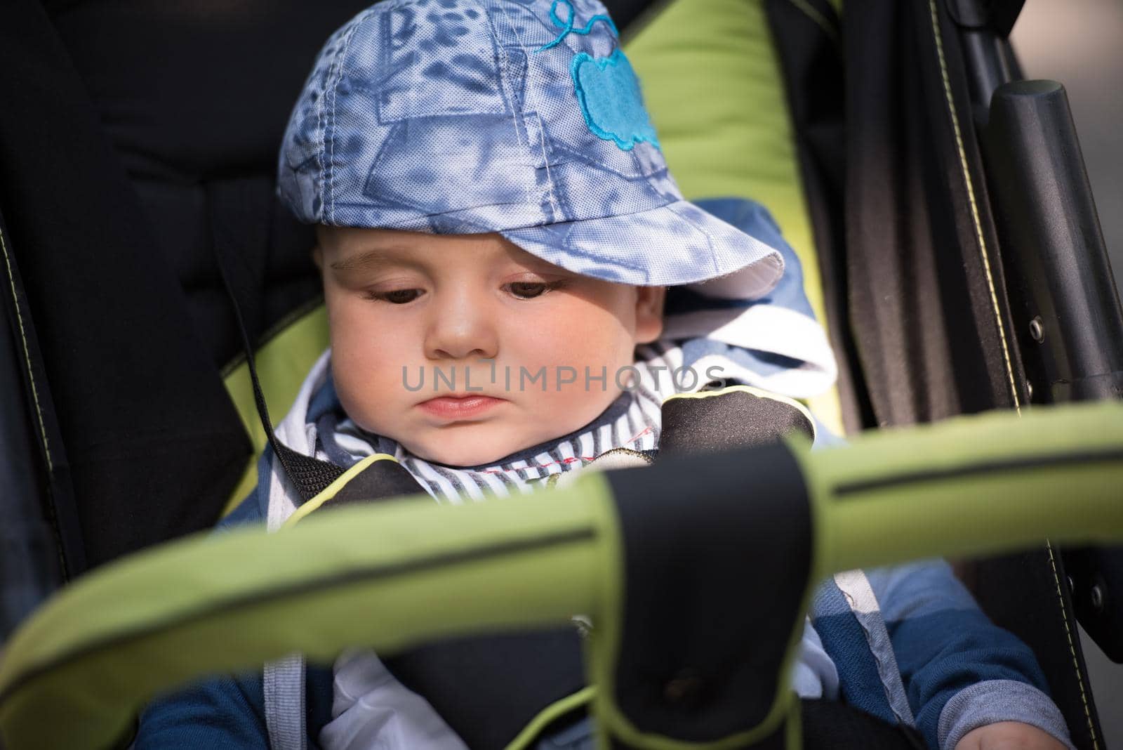 little and very beautiful baby boy sitting in the pram and waiting for mom