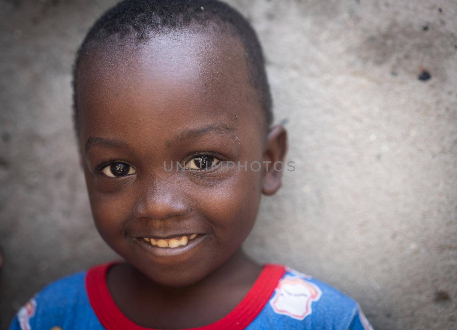 African black boy portrait standing near his poor house alone