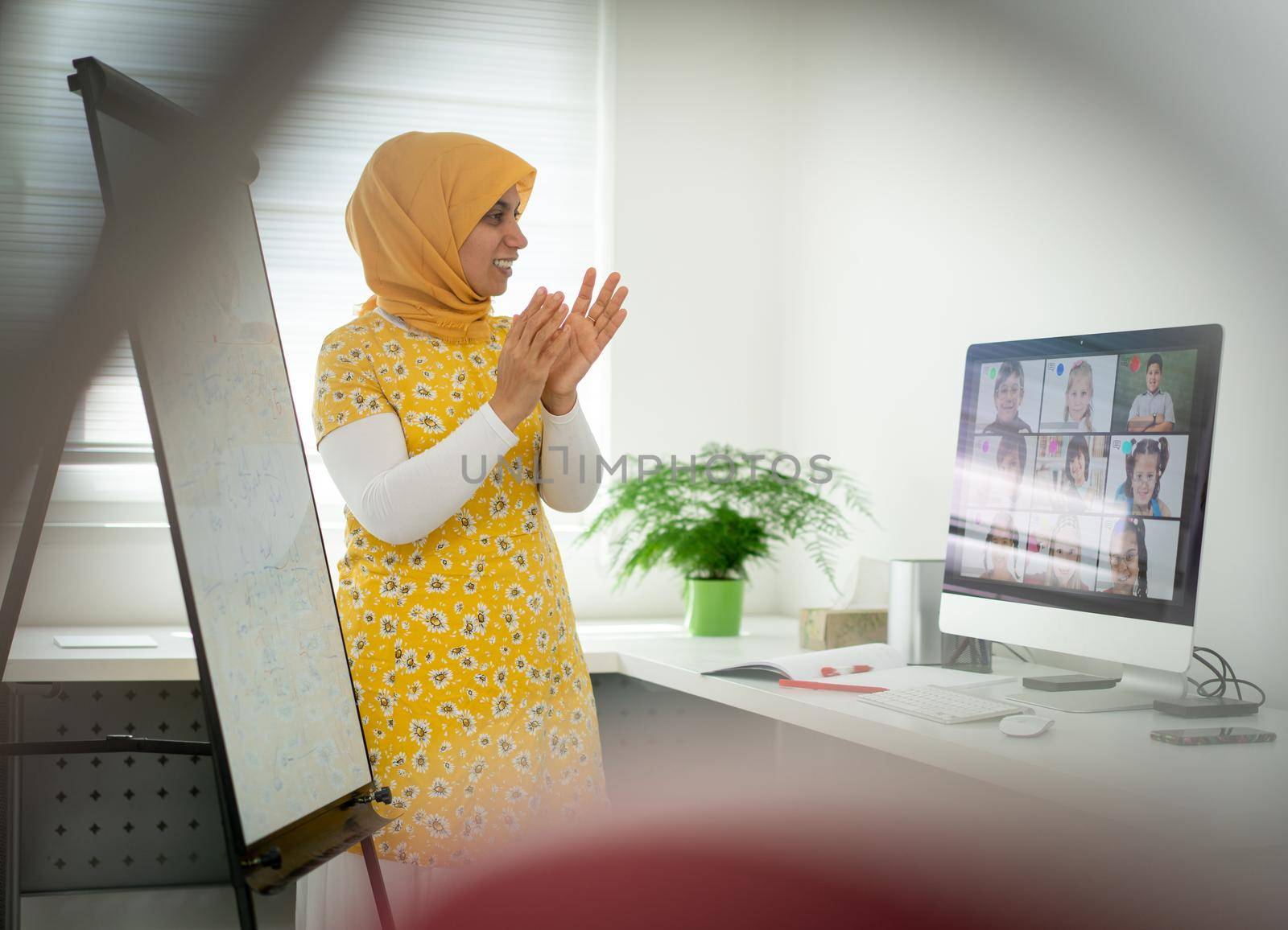 Arabic female teacher working with children online school by Zurijeta