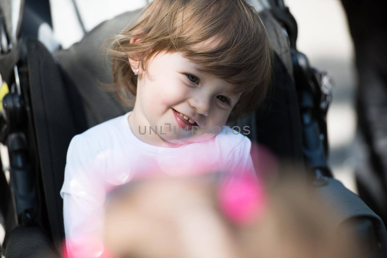 little and very beautiful baby girl sitting in the pram and waiting for mom