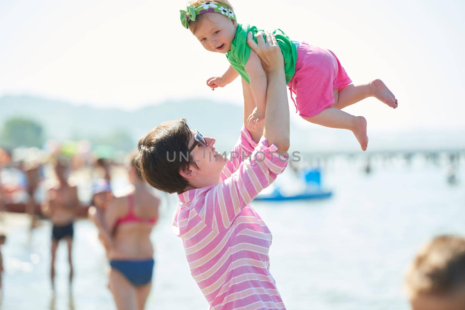 happy mom and baby on beach  have fun while learning to walk and  make first steps