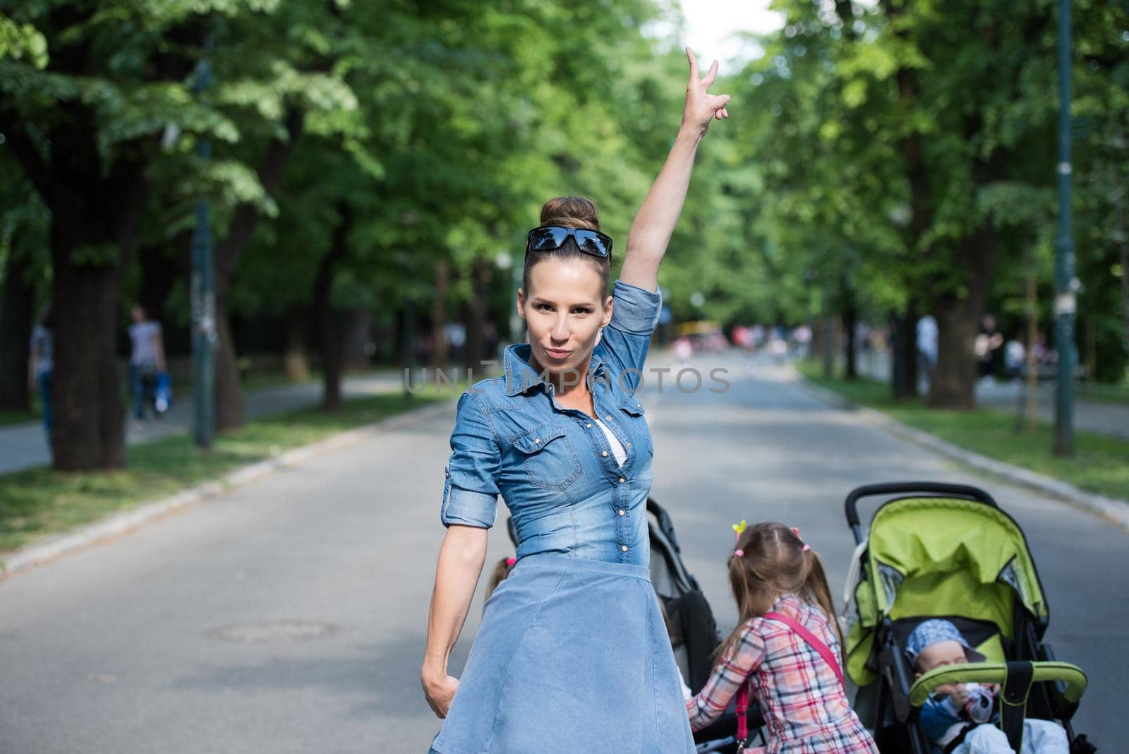 young beautiful mother enjoying with her daughters on a sunny day in the park