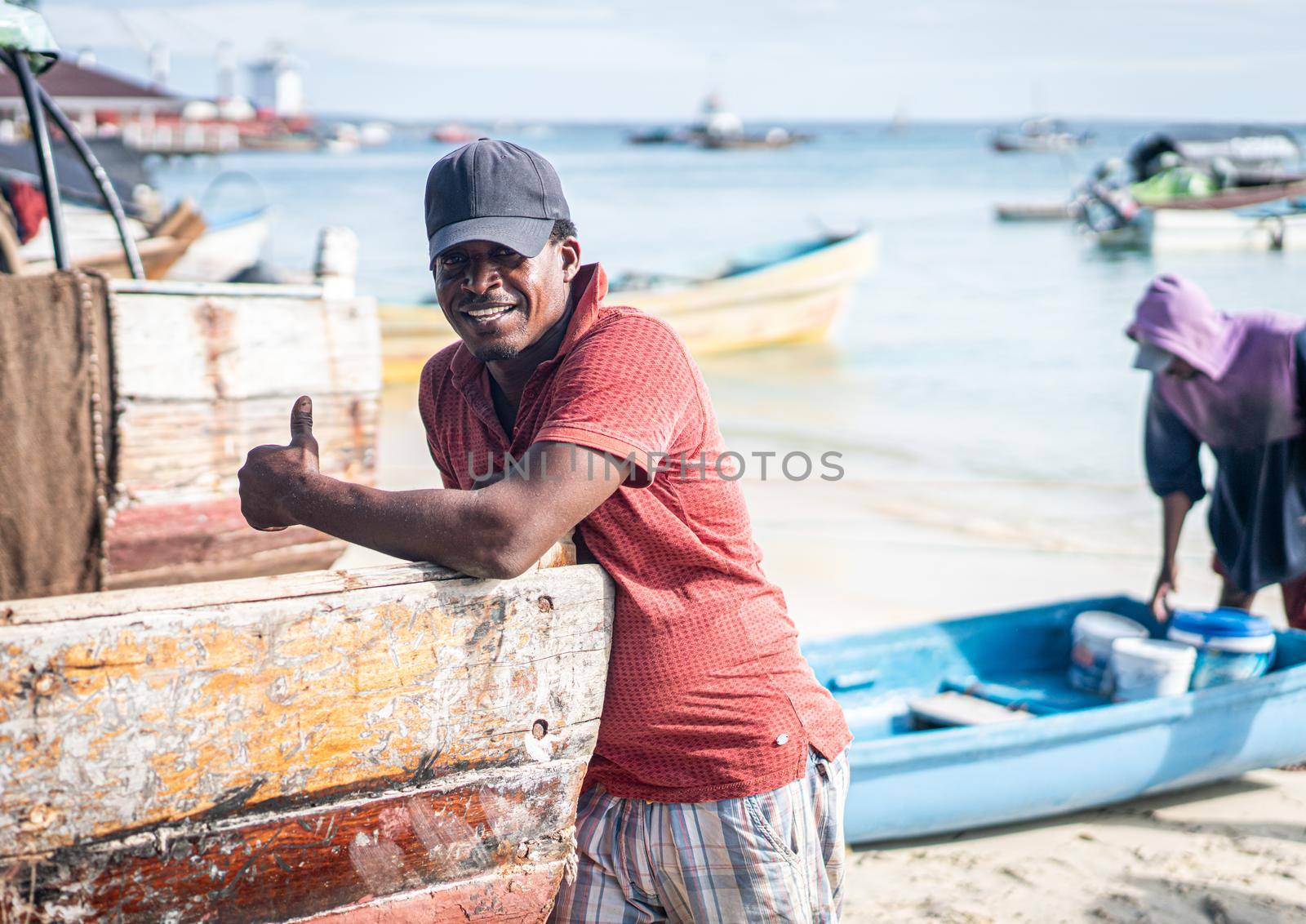 Candid black fisherman on coast ocean