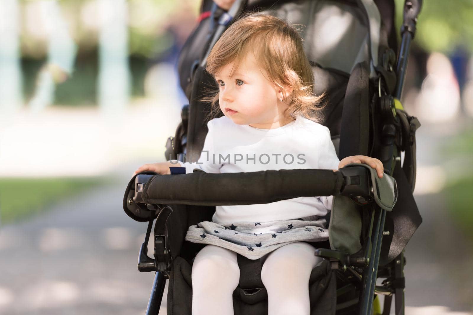 little and very beautiful baby girl sitting in the pram and waiting for mom