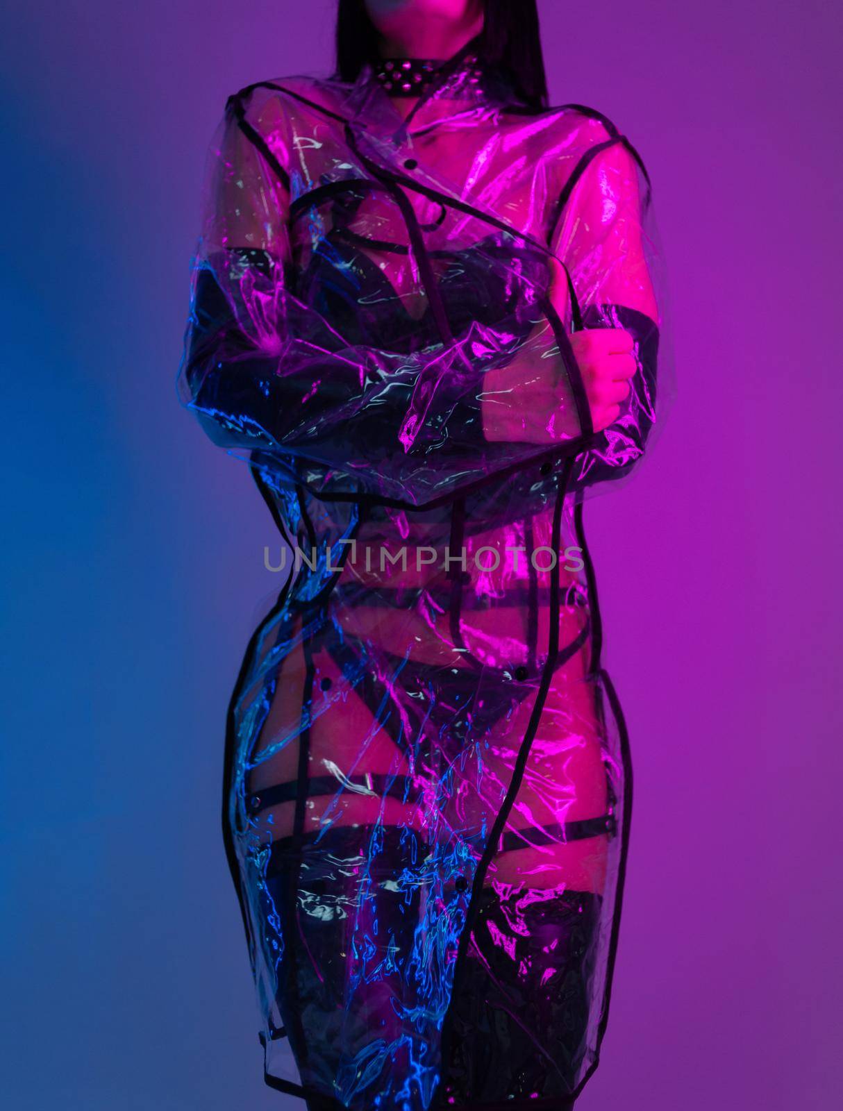 slender woman in a swimsuit and a transparent raincoat in neon light by Rotozey