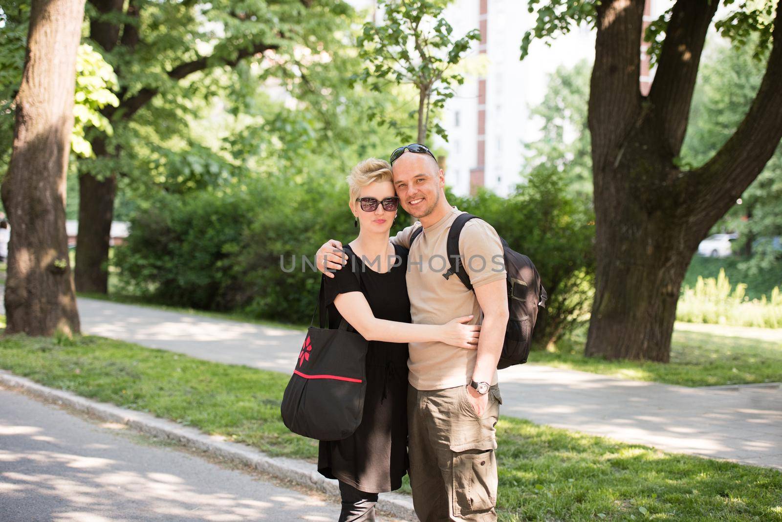 Portrait of a young beautiful happy couple on a sunny day in city park