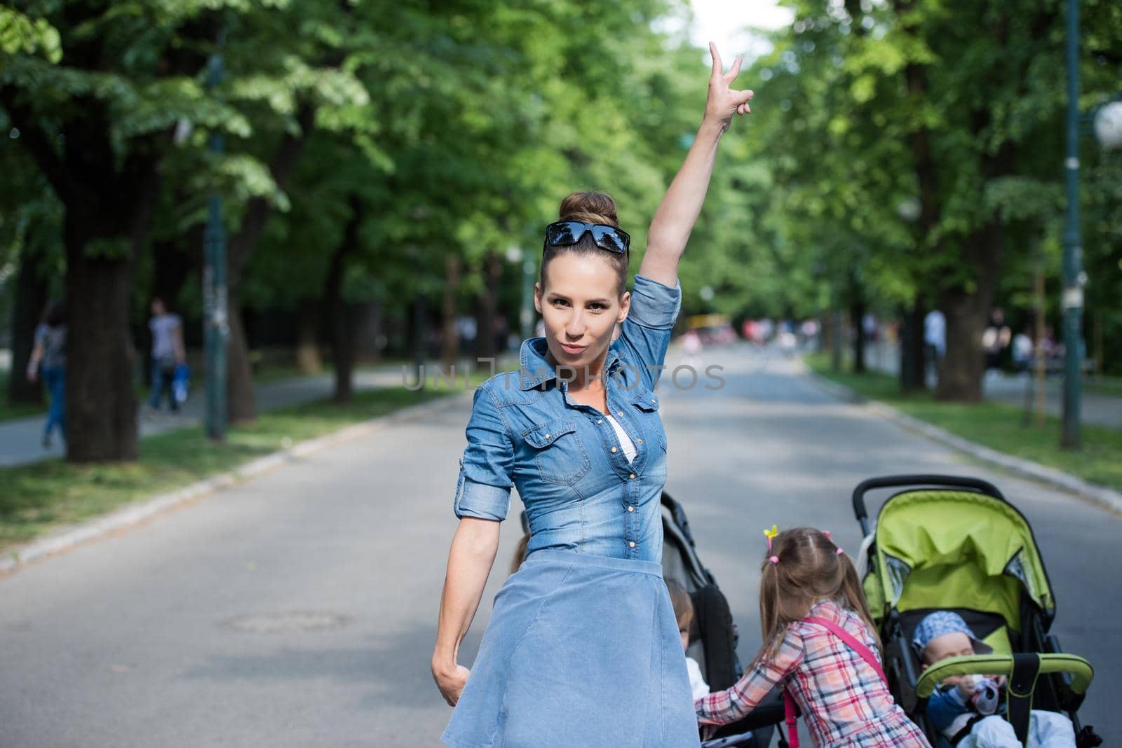 young beautiful mother enjoying with her daughters on a sunny day in the park