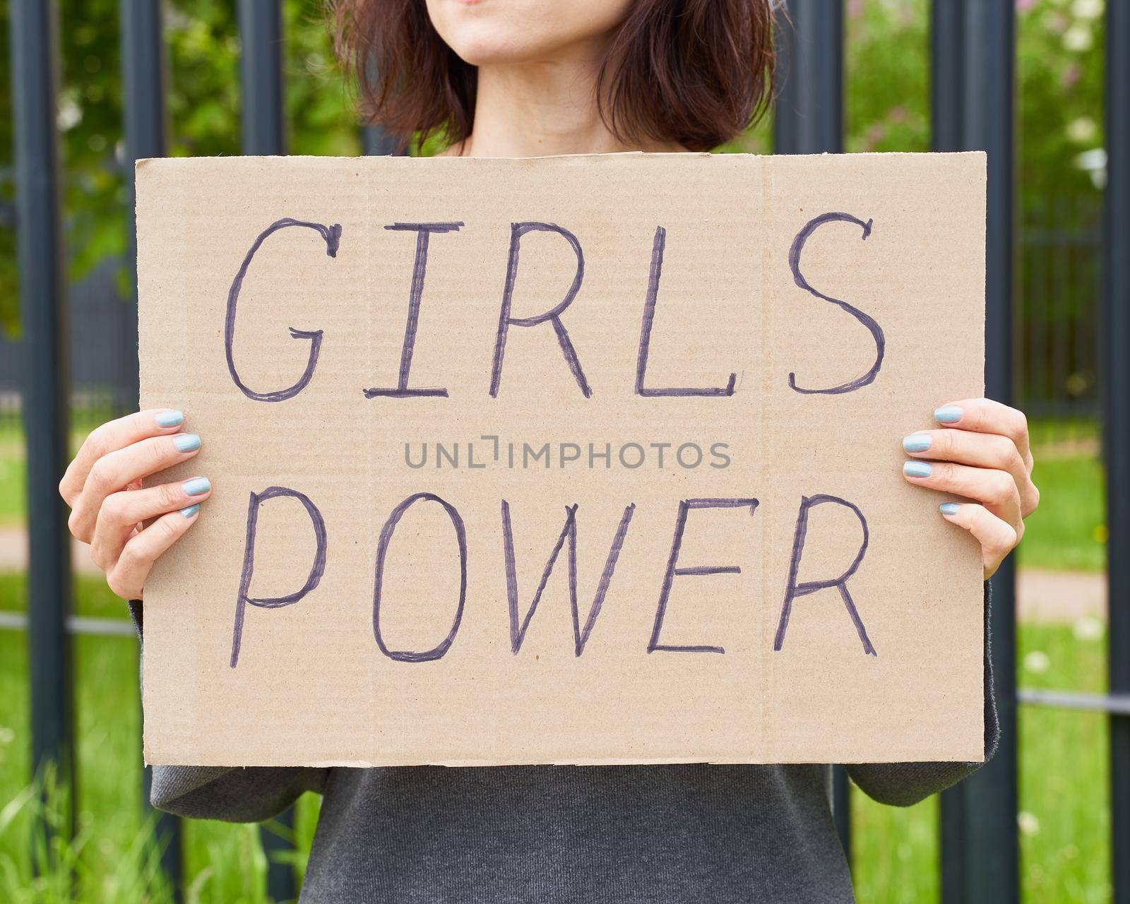 Girl Power concept. Unrecognizable person holds sign with text about feminism. Woman protests in demonstration