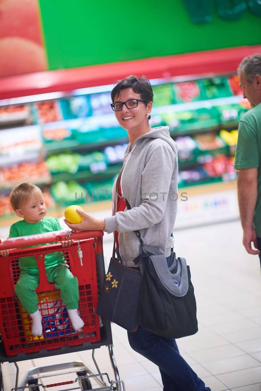 young mother with baby in shopping mall supermarket store buying food and grocery